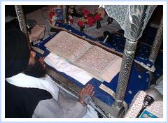 Gurudwara from inside. Priest reading from Guru Granth Sahib